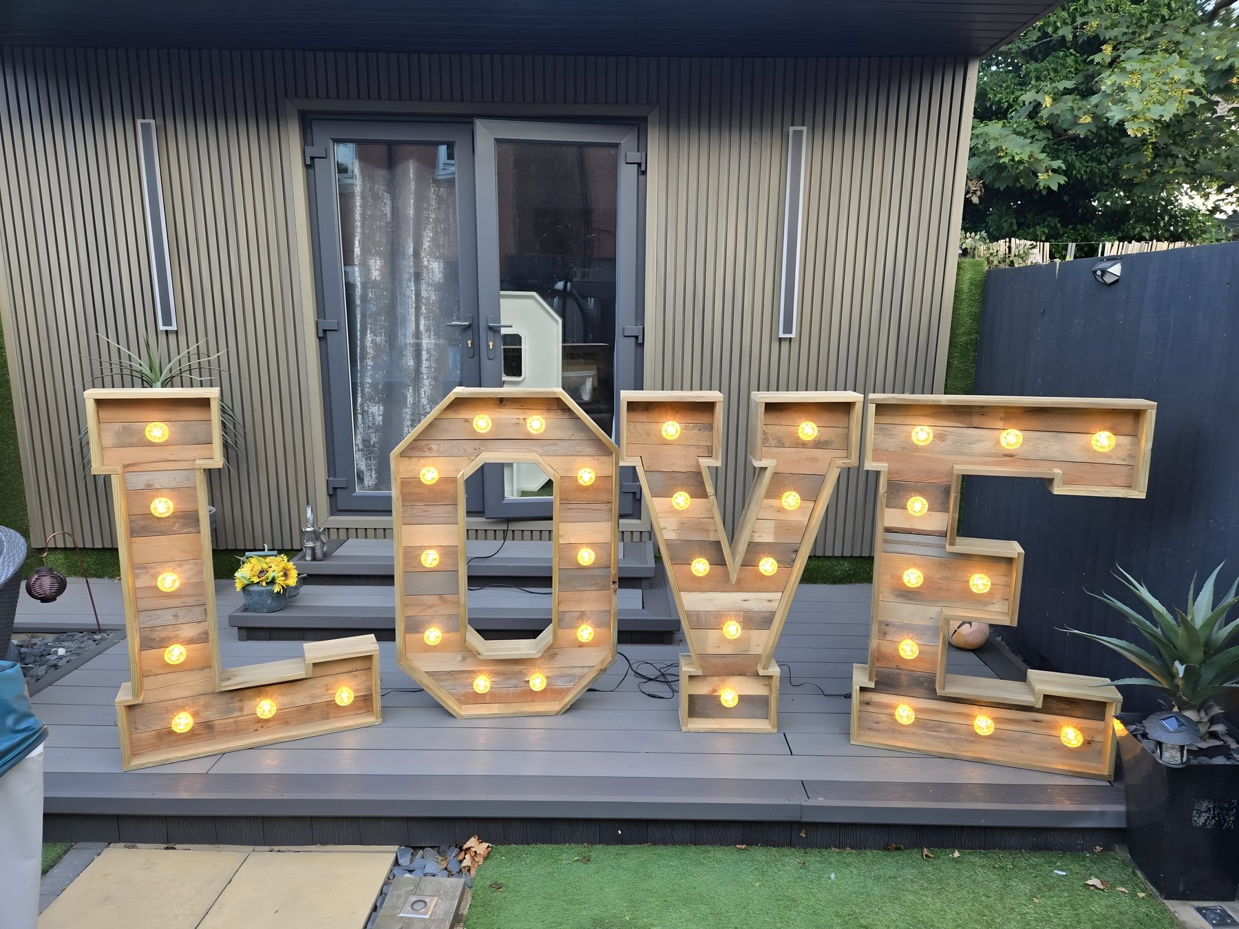 Rustic light-up LOVE letters styled in a garden setting