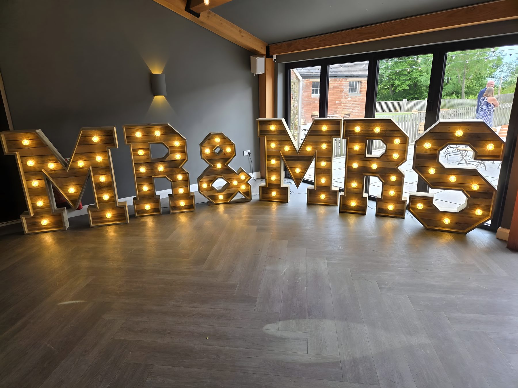Rustic wooden Mr and Mrs light-up letters at a wedding venue