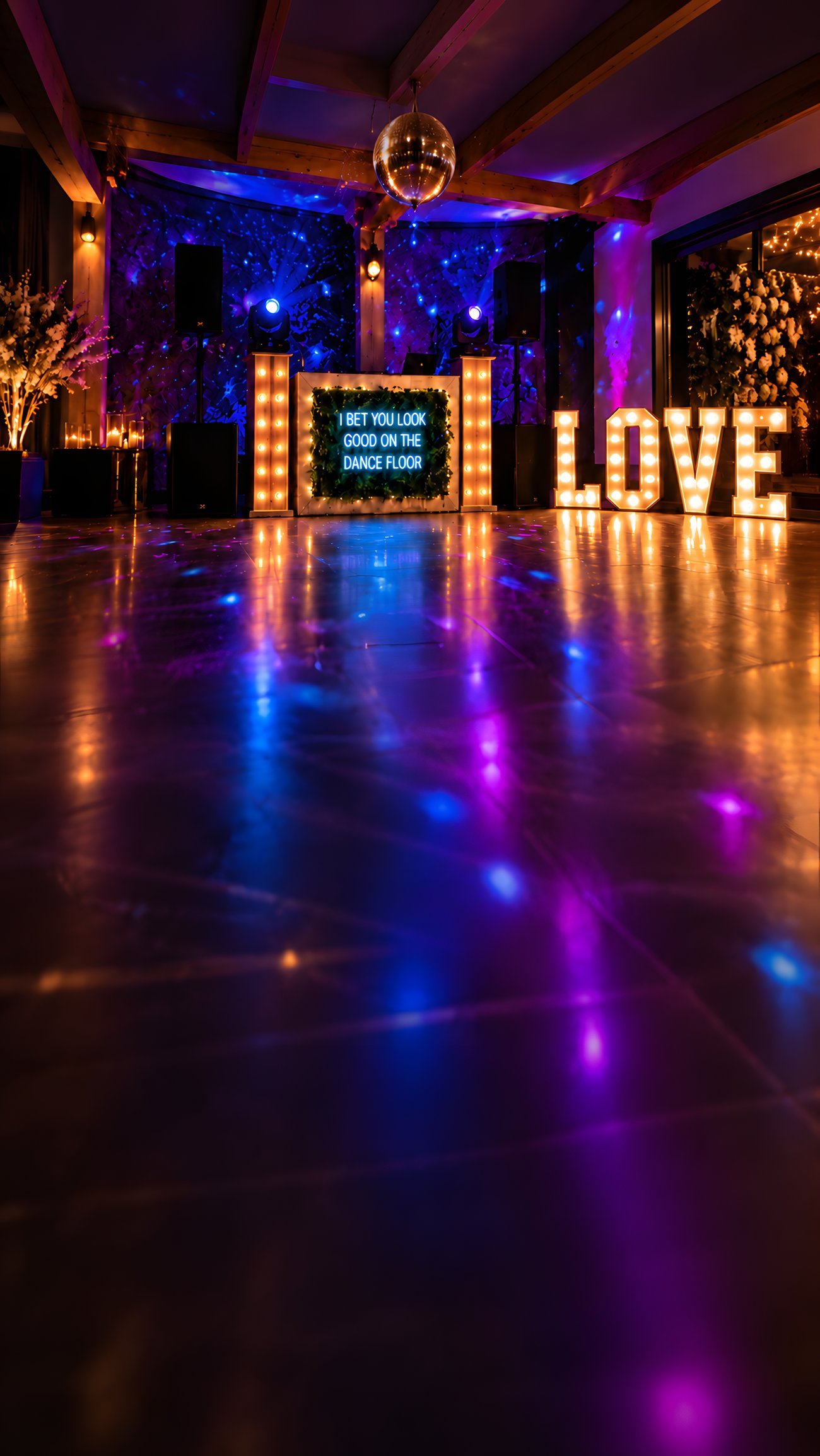 Illuminated DJ booth, disco ball and LOVE letters on a reflective dance floor